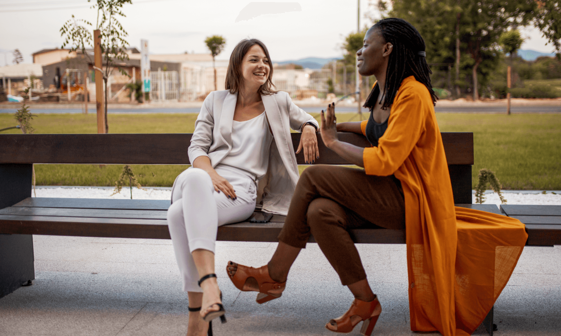 Two friends talking on a bench.